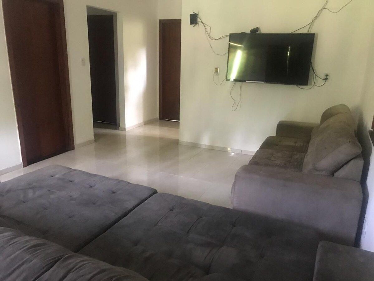 Living room with a large sofa, rug and wall-mounted TV